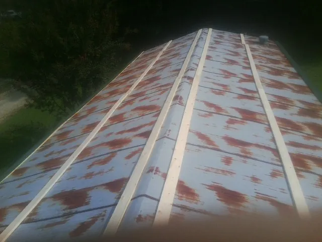 Rusted metal roof panels with new wood purlins before replacement — Storm Damage Roof Repair in Garden City by Roofing Brothers